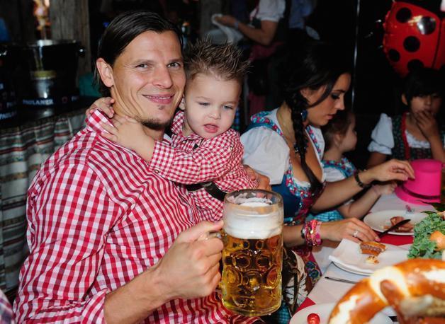 Daniel van Buyten con in braccio il figlio, tiene stretta  una bella birra. 